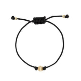 Black macrame cord bracelet with gold s on a white background