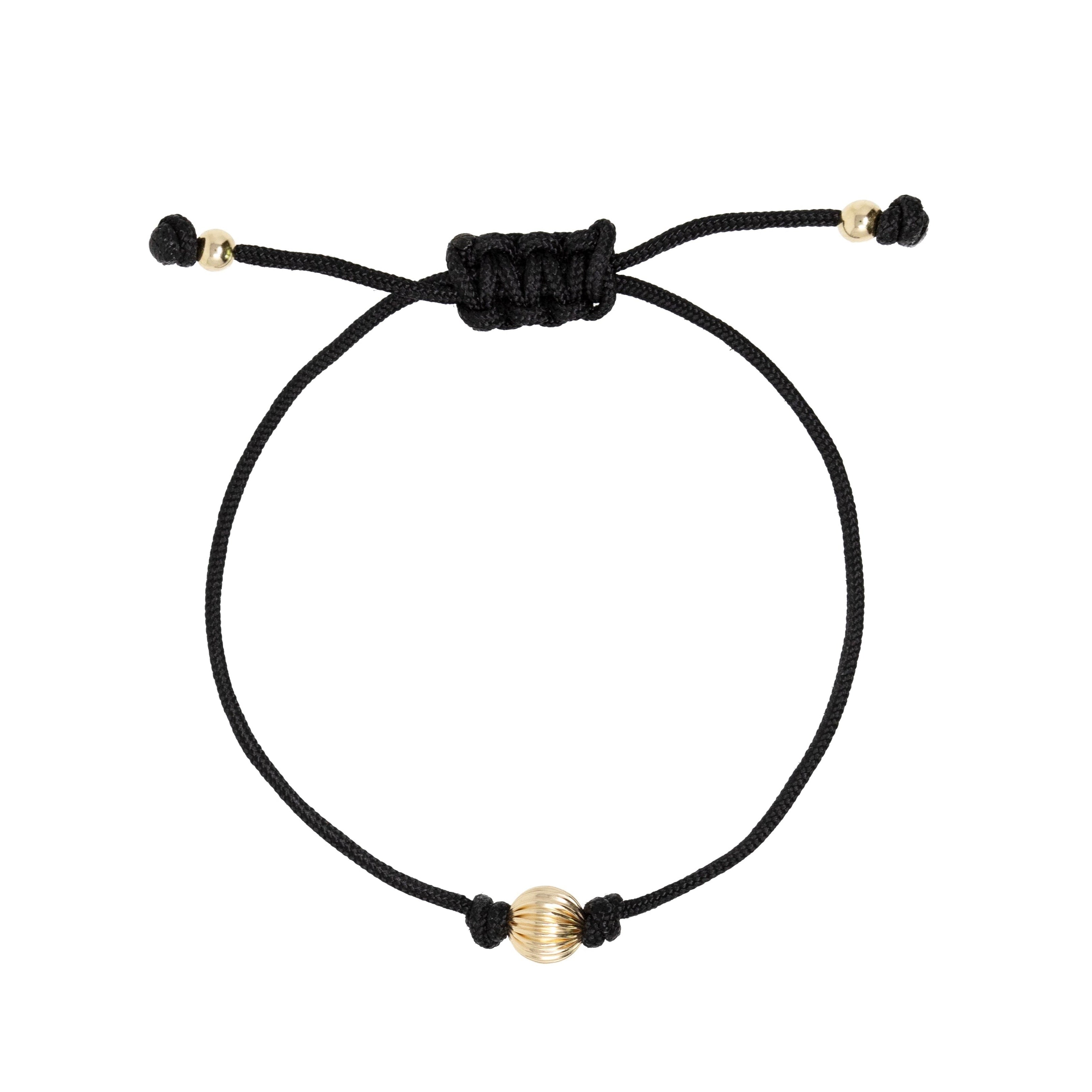Black macrame cord bracelet with gold s on a white background