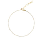 A delicate anklet featuring small, irregular white freshwater pearls threaded along a gold-tone chain with a lobster clasp and extension chain