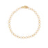 A delicate gold filled chain bracelet with repeating open quatrefoil clover links filled with white enamel inlay