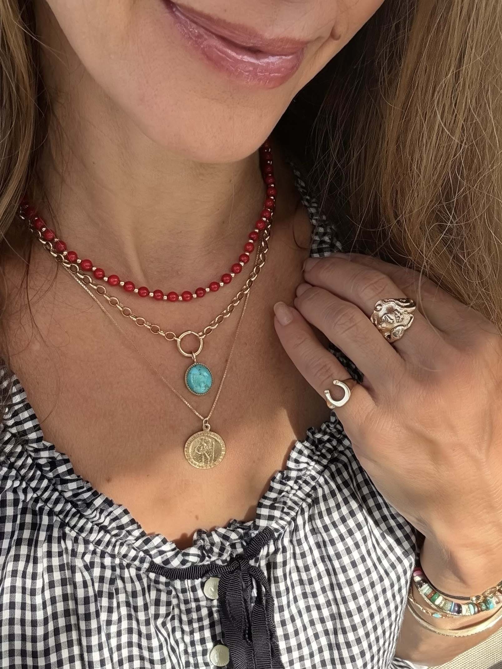 necklace stack for summer with red coral beaded strand, a gold chain with a turquoise oval pendant, and a gold chain with a round gold coin pendant.