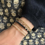 Close-up of a hand wearing gold filled bead and black agate bead bracelet gold filled chain link bracelet
